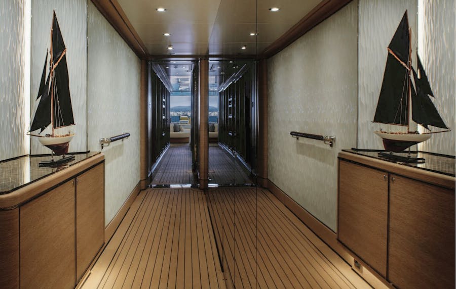 Mirrored hallway with sailboat decor on storage chest. >
