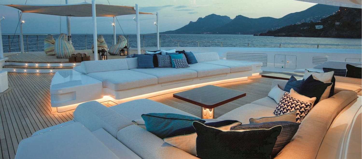 Bow of the boat lit up around the deck couches and overhead coverage. >